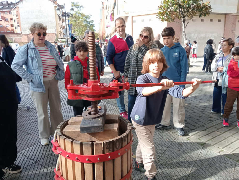 Un participante fai xirar la prensa del llagarín