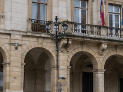 Persones llegando a un edificiu públicu, escena ficticia xenerada con IA