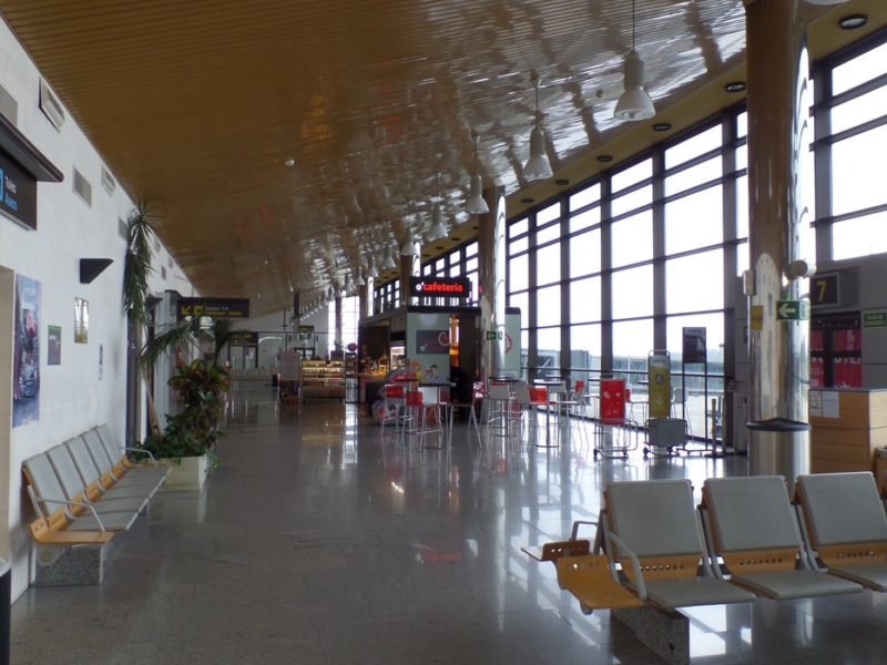 Interior de la terminal del Aeropuertu d’Asturies, con mostradores y zona de pasu de viaxeros.
