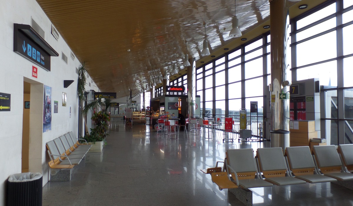 Interior de la terminal del Aeropuertu d’Asturies, con mostradores y zona de pasu de viaxeros.