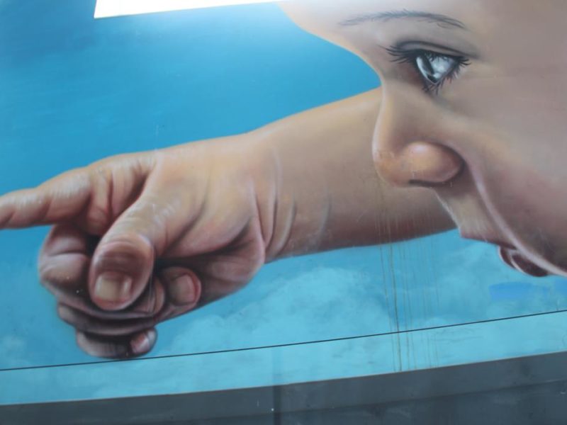 Mural d’un neñu na plaza Santiago López d’Avilés, nel entornu de l’Antigua Pescadería.