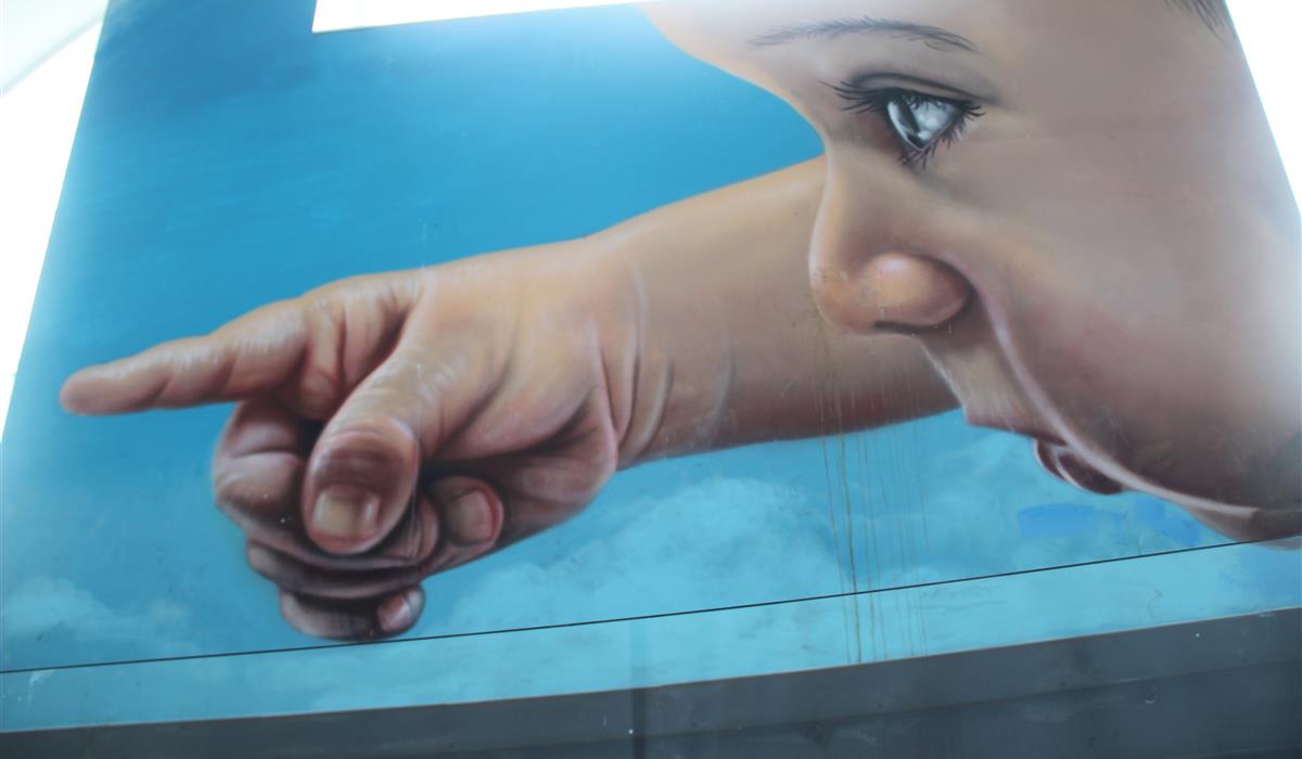 Mural d’un neñu na plaza Santiago López d’Avilés, nel entornu de l’Antigua Pescadería.