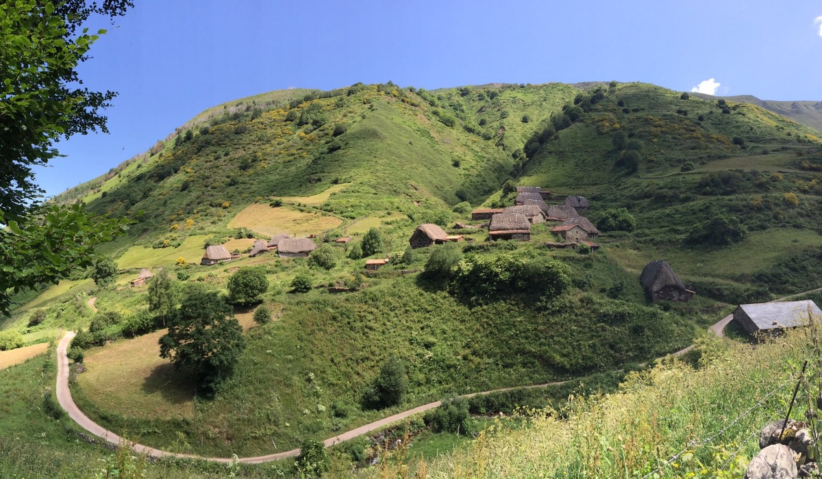 Braña La Pornacal, en Somiedu, con construcciones tradicionales de techu vexetal nuna ladera verde