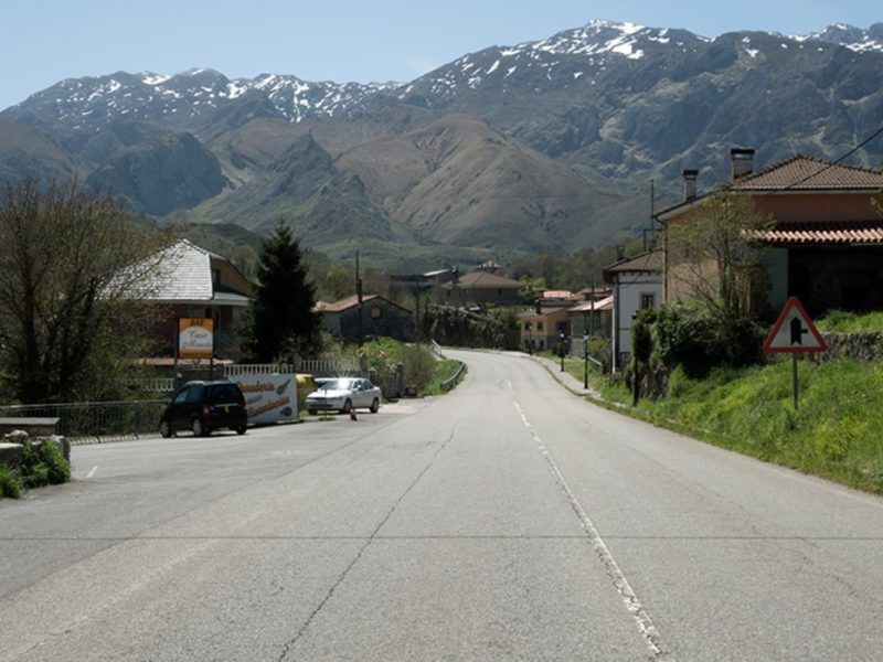 Carretera y cases d’Ortiguero, en Cabrales, coles montañes al fondu