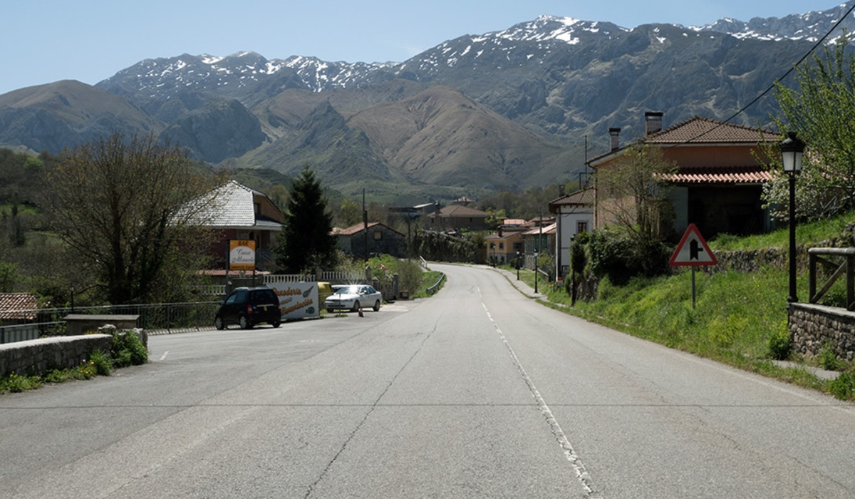 Carretera y cases d’Ortiguero, en Cabrales, coles montañes al fondu