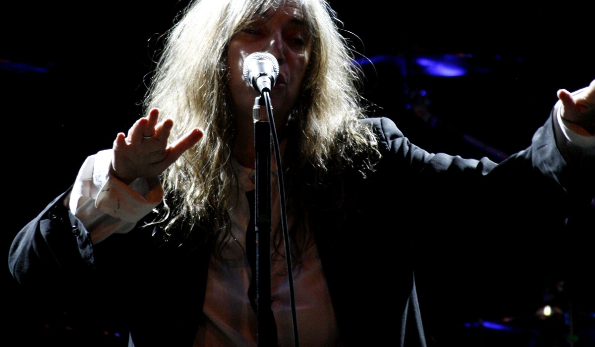 Patti Smith canta nun escenariu con un micrófonu durante un conciertu.