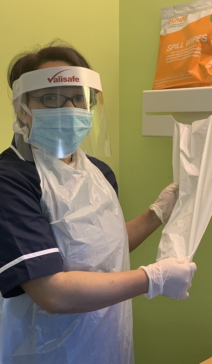 Profesional d’enfermería con equipu de protección nun centru d’atención primaria.